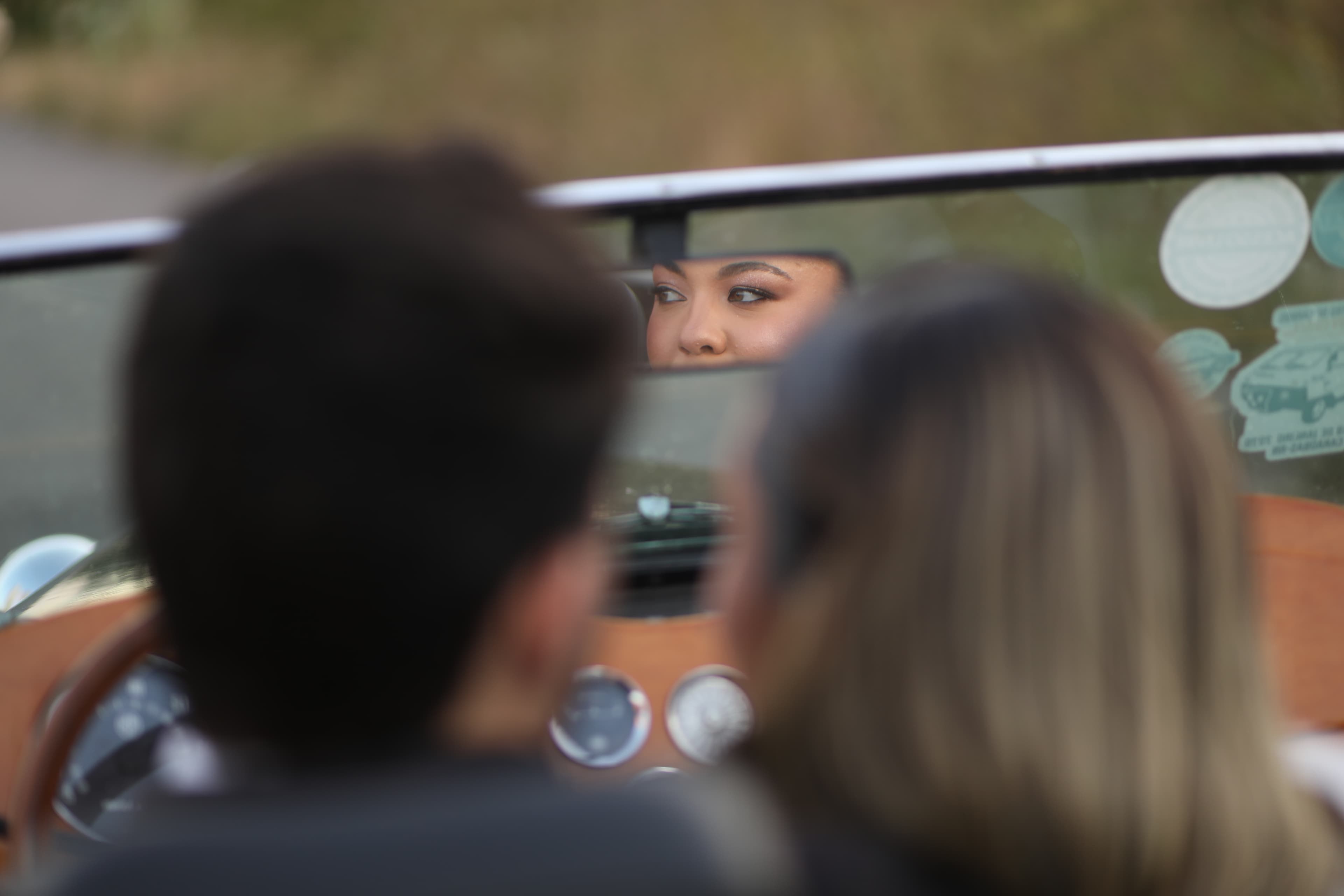 O olhar entre o retrovisor central do carro, enquanto os dois olham o seu destino a frente (o casamento).